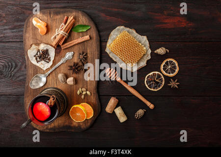 Verre de vin chaud (poinçon) Porte-verre en servi sur plaque en bois avec des épices sur la table en bois sombre. Vue d'en haut Banque D'Images