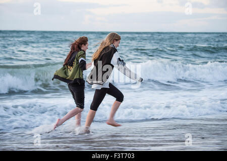 Aberystwyth, Pays de Galles, Royaume-Uni. 12 octobre, 2015. Météo France : à la fin d'une journée de ciel clair et soleil, deux jeunes femmes braver le froid de l'eau pour pagayer dans les vagues au coucher du soleil sur la baie de Cardigan à Aberystwyth, Pays de Galles au Royaume-Uni. La semaine à venir devrait être beau et sec, mais avec le risque de gel la nuit dans des lieux Crédit : Keith morris/Alamy Live News Banque D'Images