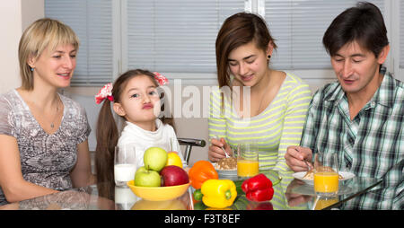 Famille assis à table en train de manger repas ensemble Banque D'Images