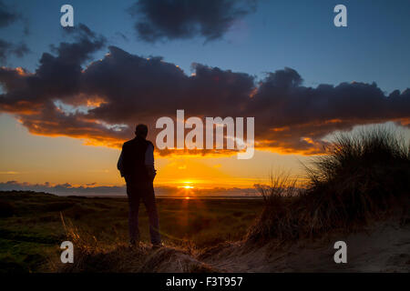 Southport, Merseyside, UK 12 Octobre, 2015. L'homme Silhouette. Météo britannique. De soleil colorés sur la mer d'Irlande et les dunes de sable d'Ainsdale National Nature Reserve (NNR), qui est une 508 hectares composé de rares dunes, de la plage et des habitats forestiers. Il y a 10 kms de sentiers à suivre, un cadre paisible et sauvage entouré d'un des la plupart des zones urbaines en Angleterre. Banque D'Images