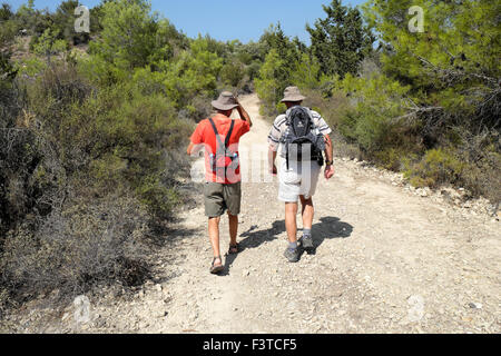 Vue arrière de deux hommes à pied avec des sacs à dos sur un chemin près de la côte dans le Nord turc Kaplica Chypre KATHY DEWITT Banque D'Images