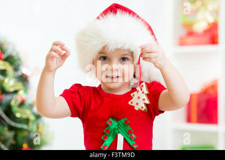 Kid in Santa hat holding Christmas Cookies Banque D'Images