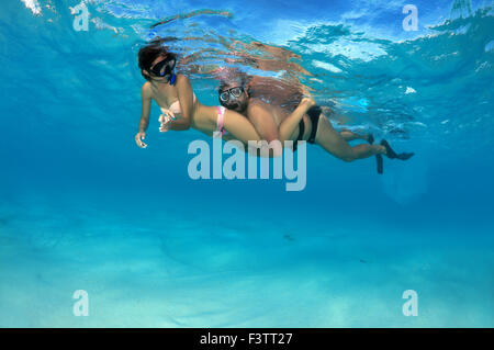 Jeune beau couple flottant au-dessus d'un fond de sable, de l'Océan Indien, les Maldives Banque D'Images