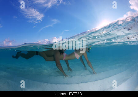 Jeune beau couple flottant au-dessus d'un fond de sable, de l'Océan Indien, les Maldives Banque D'Images
