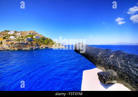 Une vue sur la magnifique île grecque d'Hydra la côte opposée, qui est gardé par des canons Banque D'Images