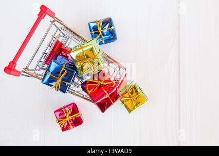 Panier plein de cadeaux colorés sur fond de bois. Vue d'en haut. Banque D'Images