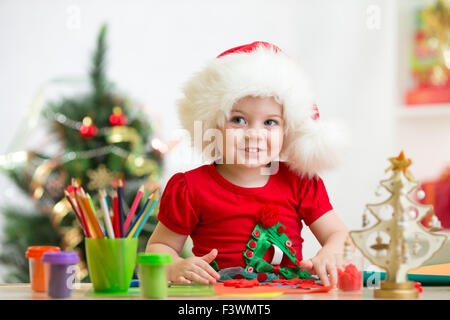 Enfant girl in Santa hat faire noël décoration de pâte à modeler Banque D'Images