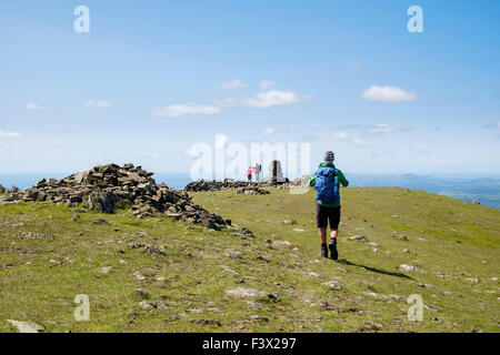 L'approche de randonneurs sur cairn point trig Moel Hebog sommet de montagne dans la région de montagnes de Snowdonia National Park, au nord du Pays de Galles, Royaume-Uni Banque D'Images