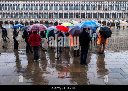 Piazza San Marco, la Place Saint Marc, Venise, Italie. 13 octobre 2015. Voyages en groupe avec parasols écouter leur guide à l'état humide, jour de pluie à Venise. Crédit : Richard Wayman/Alamy Live News Banque D'Images