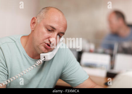 Businessman talking on phone in office Banque D'Images