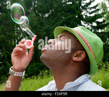 L'homme à chapeau vert blowing bubbles Banque D'Images