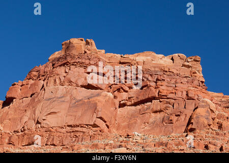 Les roches rouges et orange d'une haute falaise, offrent un contraste saisissant avec le bleu ciel dans le désert de l'Arizona. Banque D'Images