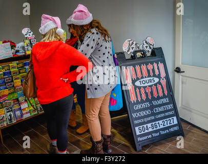 Vue arrière d'UN trio de femmes portant des chapeaux roses, visitez le bureau d'histoire hanté pour les visites de Voodoo et de fantômes dans le quartier français de la Nouvelle-Orléans, LA Banque D'Images