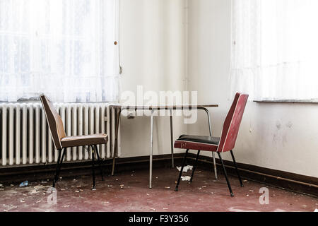 Table vide et deux chaises dans une chambre en désordre Banque D'Images