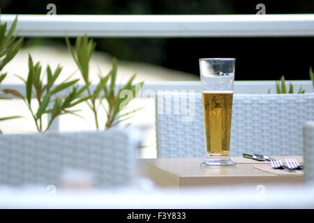 Verre de bière sur une terrasse blanche summerly Banque D'Images