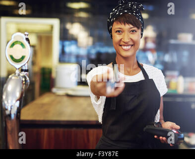 Belle vivacité young African American bar offre la restitution d'une carte bancaire après paiement d'un traitement conceptuel petit b Banque D'Images