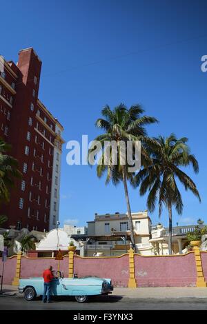 Havana street à Vedado avec ciel bleu immeuble les palmiers et vintage open top car and driver Cuba Banque D'Images