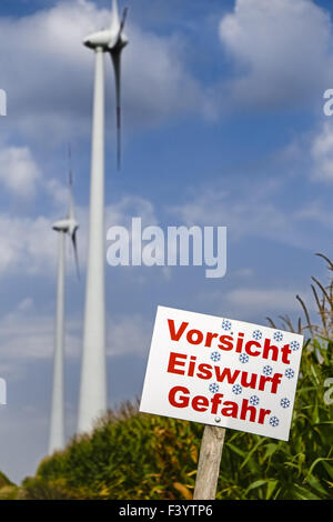 Le signe de danger en face des éoliennes Banque D'Images