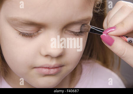 Les peintures de l'artiste maquillage paupières sur le visage de fille Banque D'Images
