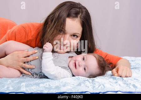 Maman et bébé de 7 mois fun lying on couch Banque D'Images