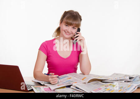 Girl appelle à une annonce dans le journal Banque D'Images