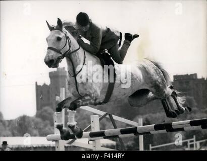 Effacement de la clôture en grand style Mesdames Ouvrez Concours de saut à Windsor Horse Show Miss Margaret Lockhart fait une grande étude comme sa monture prend une clôture dans un cadre raffiné dans la compétition de saut à ouverture Mesdames au Royal Windsor Horse Show tenu à Home Park, le château de Windsor, hier. 10 janvier, 1962. © Keystone Photos USA/ZUMAPRESS.com/Alamy Live News Banque D'Images