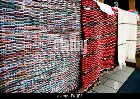 Des tapis traditionnels étant affiché sur un socle, sur un marché à Brasov, Roumanie Banque D'Images