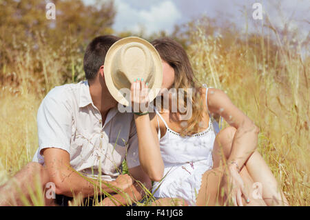 Couple dans le champ derrière un chapeau de paille Banque D'Images