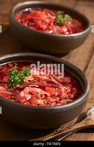 Soupe bortsch végétarien d'origine ukrainienne a fait de betterave, carotte, chou, pomme de terre, l'oignon et le céleri dans bols rustiques Banque D'Images