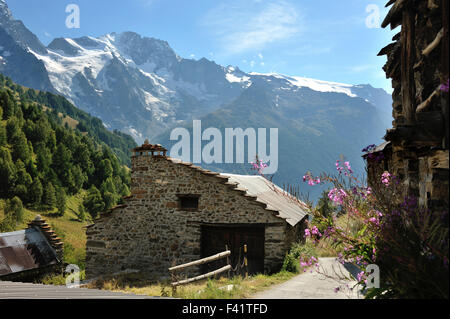 Maisons de pierre et de bois dans le petit hameau entouré par de magnifiques paysages de montagne dans la région de Valfroide, Alpes, France Banque D'Images