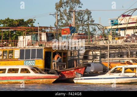 Jeune garçon assis sur un bateau amarré sur le Mékong près de Can Tho, Delta du Mékong, Vietnam du Sud-ouest Banque D'Images