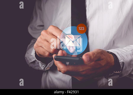 Businessman de l'affichage des messages sur téléphone intelligent, doigt sur l'écran tactile de l'appareil sans fil en poussant l'icône de l'application, r Banque D'Images
