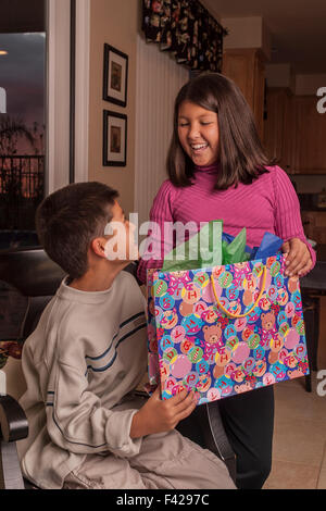 L'interracial multicultural multi ethnic Korean/Caucasian frère et sœur présente ouverture giving gift. M. ©Pearson Myrleen Banque D'Images