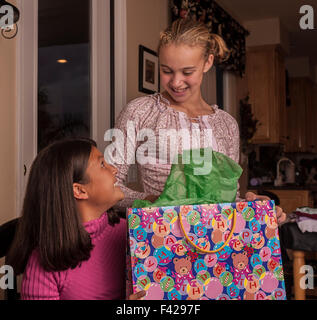Donner à l'enfant l'enfant cadeaux interracial multi ethnic multiculturel brésilien et Coréen best girl friends présente l'ouverture des cadeaux. M. ©Pearson Myrleen Banque D'Images
