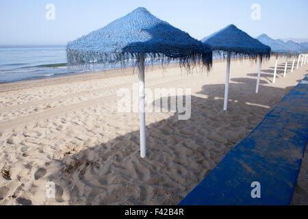 Parapluies bleu rustique fait de fibres naturelles sur une belle plage de Costa del Sol Espagne Banque D'Images