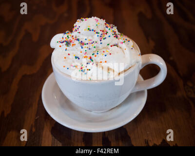 Un gâteau chaud avec latté et saupoudre de couleur crème fouettée de d'établir par Tish Café à Saskatoon, Saskatchewan, Canada. Banque D'Images