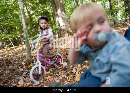 Little girl riding bike en zone boisée Banque D'Images