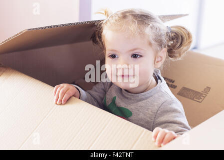 Little girl playing in cardboard box Banque D'Images