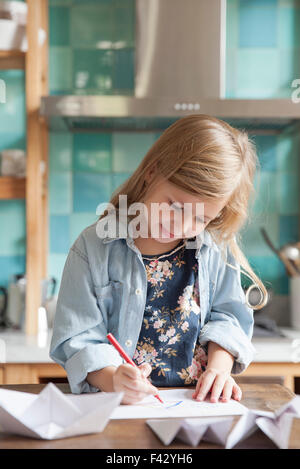 Petite fille dessin dans cuisine, portrait Banque D'Images