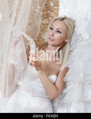 Happy bride essaie sur une robe de mariage Banque D'Images