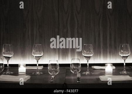 Set de table avec des verres à vin, des serviettes et des bougies dans un restaurant de la ville. Image en noir et blanc. Banque D'Images