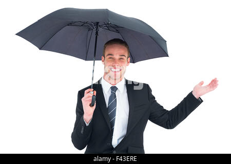 Businessman s'abritant sous parapluie noir Banque D'Images