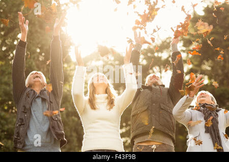 Famille heureuse Jeter feuilles autour de Banque D'Images