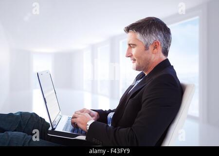 Image composite de businessman using laptop Banque D'Images