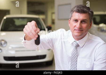 Smiling salesman donnant les clés de la voiture d'un client Banque D'Images