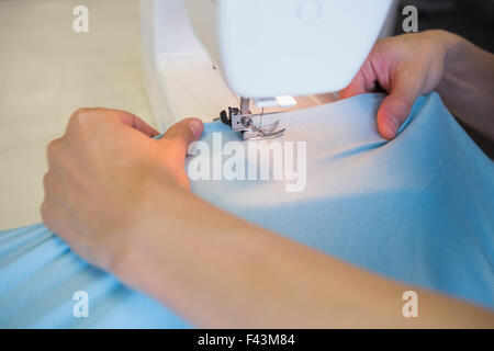 Close up of student using sewing machine Banque D'Images