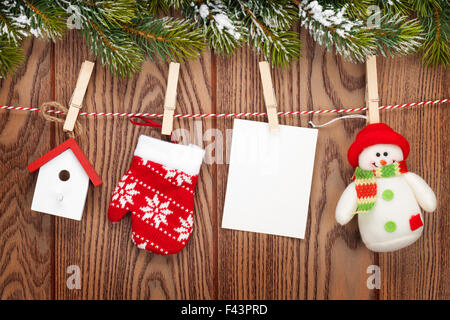 Sapin de neige, cadres photo et décoration de Noël sur corde sur planche en bois rustique avec copie espace Banque D'Images