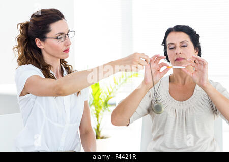 Femme d'être hypnotisé pour cesser de fumer Banque D'Images