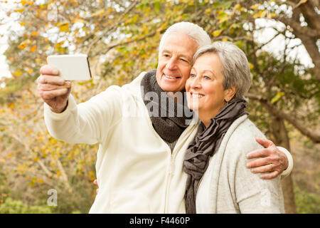 Couple dans le parc prendre selfies Banque D'Images