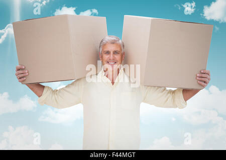 Image composite de l'homme heureux holding boxes Banque D'Images